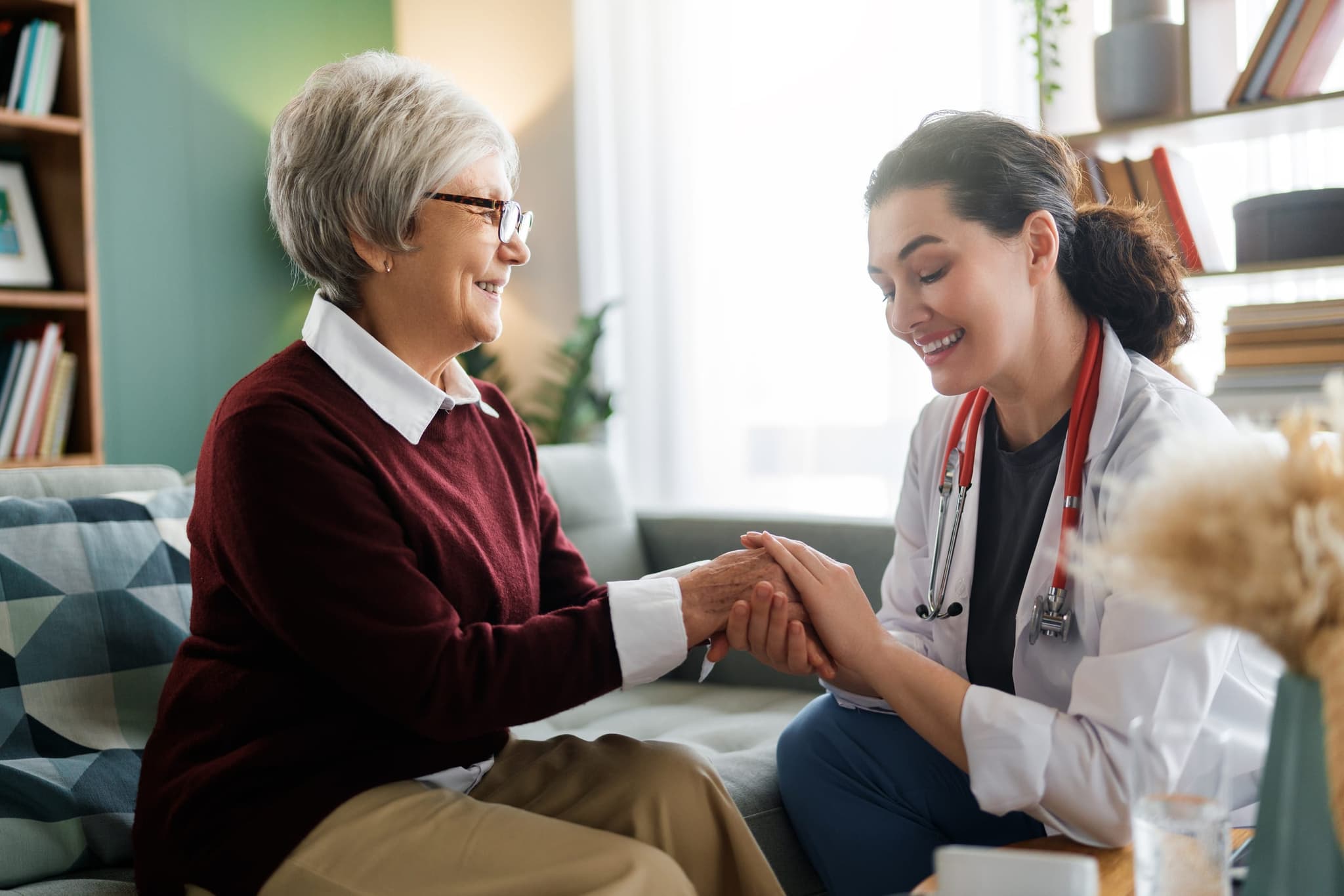 A nephrologist walking alongside a patient through a sunlit clinic corridor