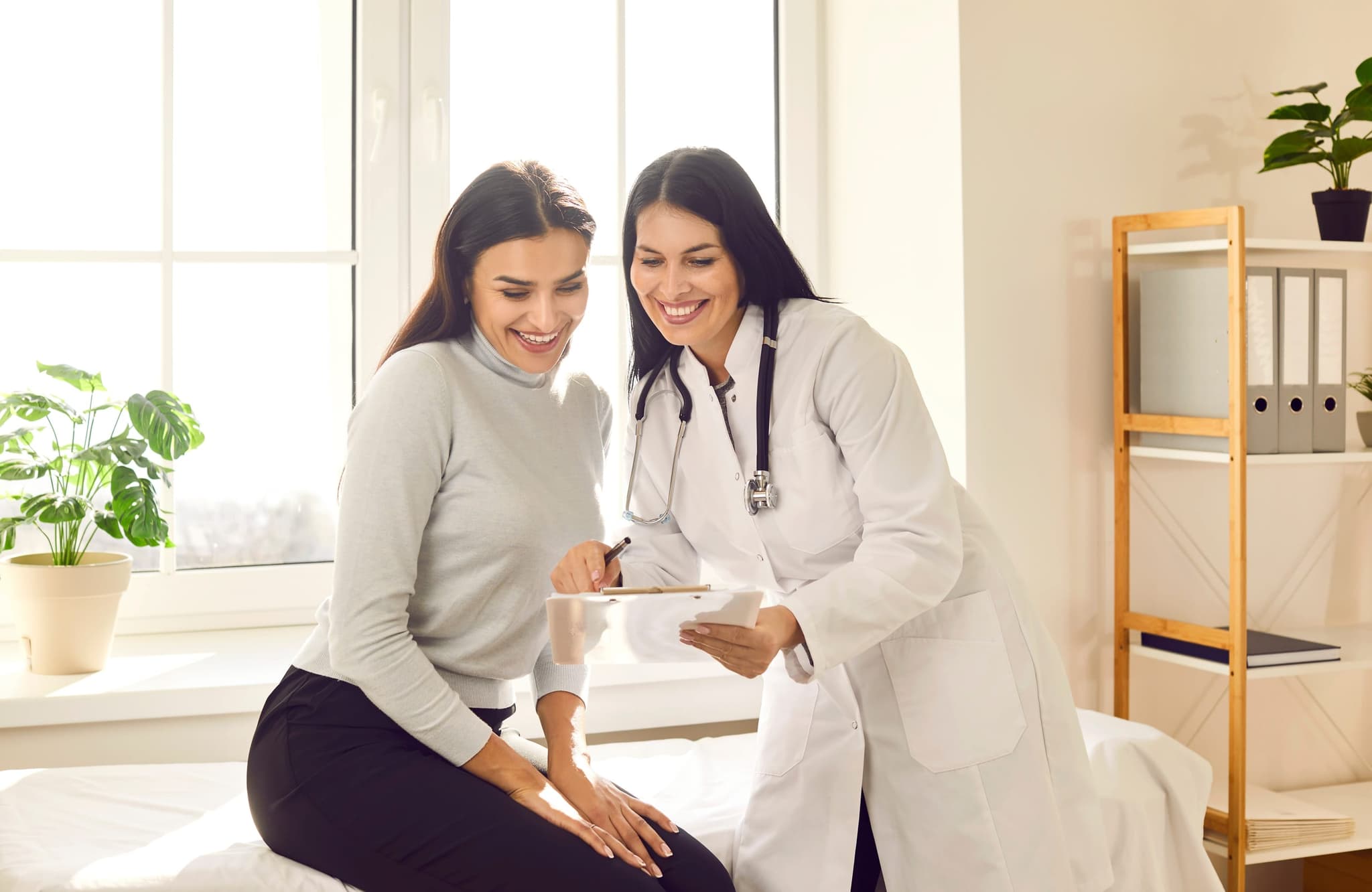 A clinician reviewing lab results with a patient at a desk
