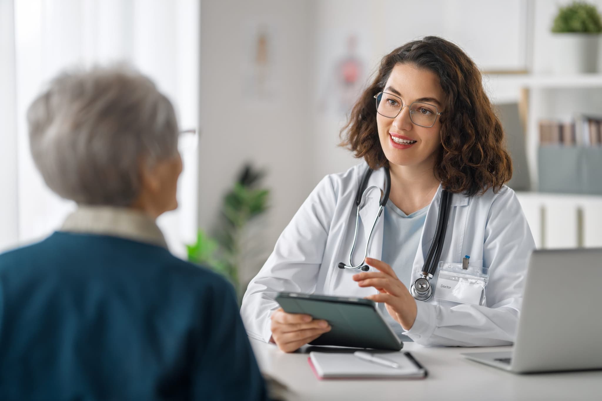 A physician reviewing kidney lab results with a patient on a tablet