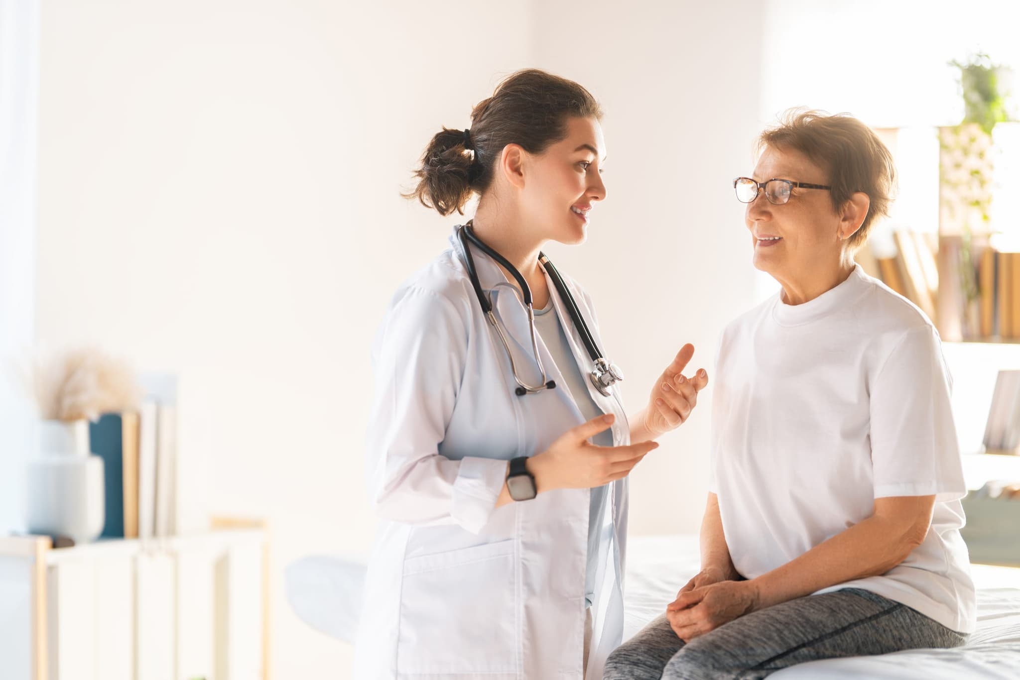 An infusion nurse adjusting an IV line and checking in with a smiling patient